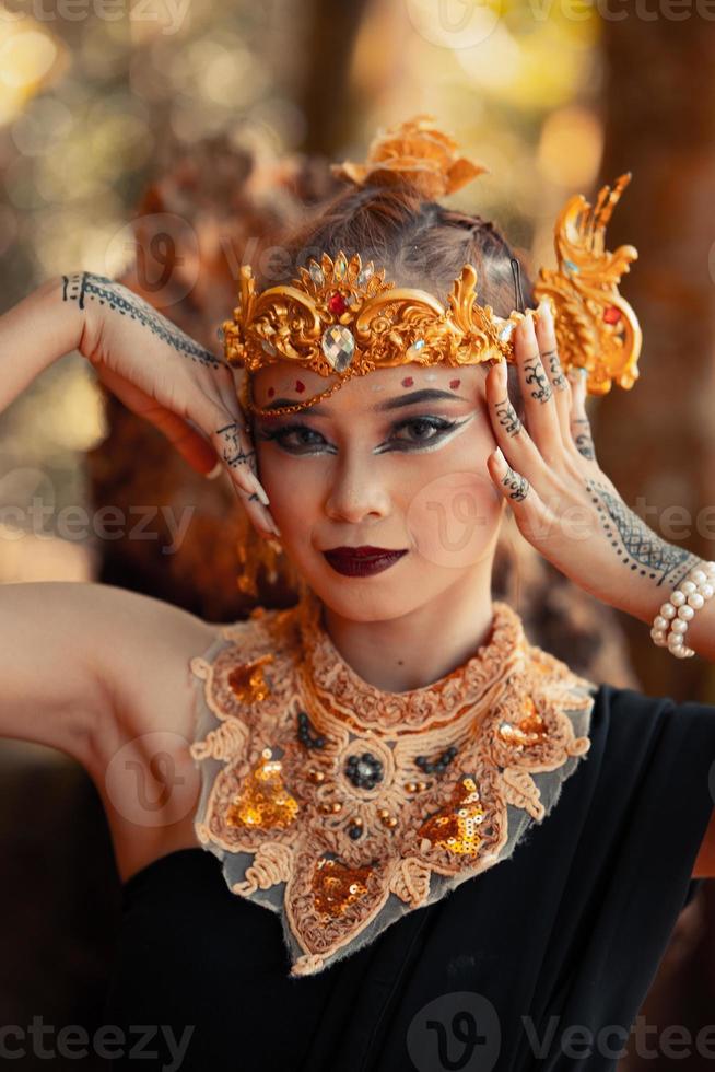 portrait d'une reine dans sa couronne d'or et un collier d'or avec du maquillage sur son visage souriant photo