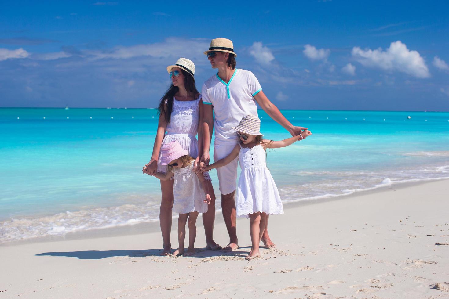 famille de quatre personnes sur une plage de sable blanc photo