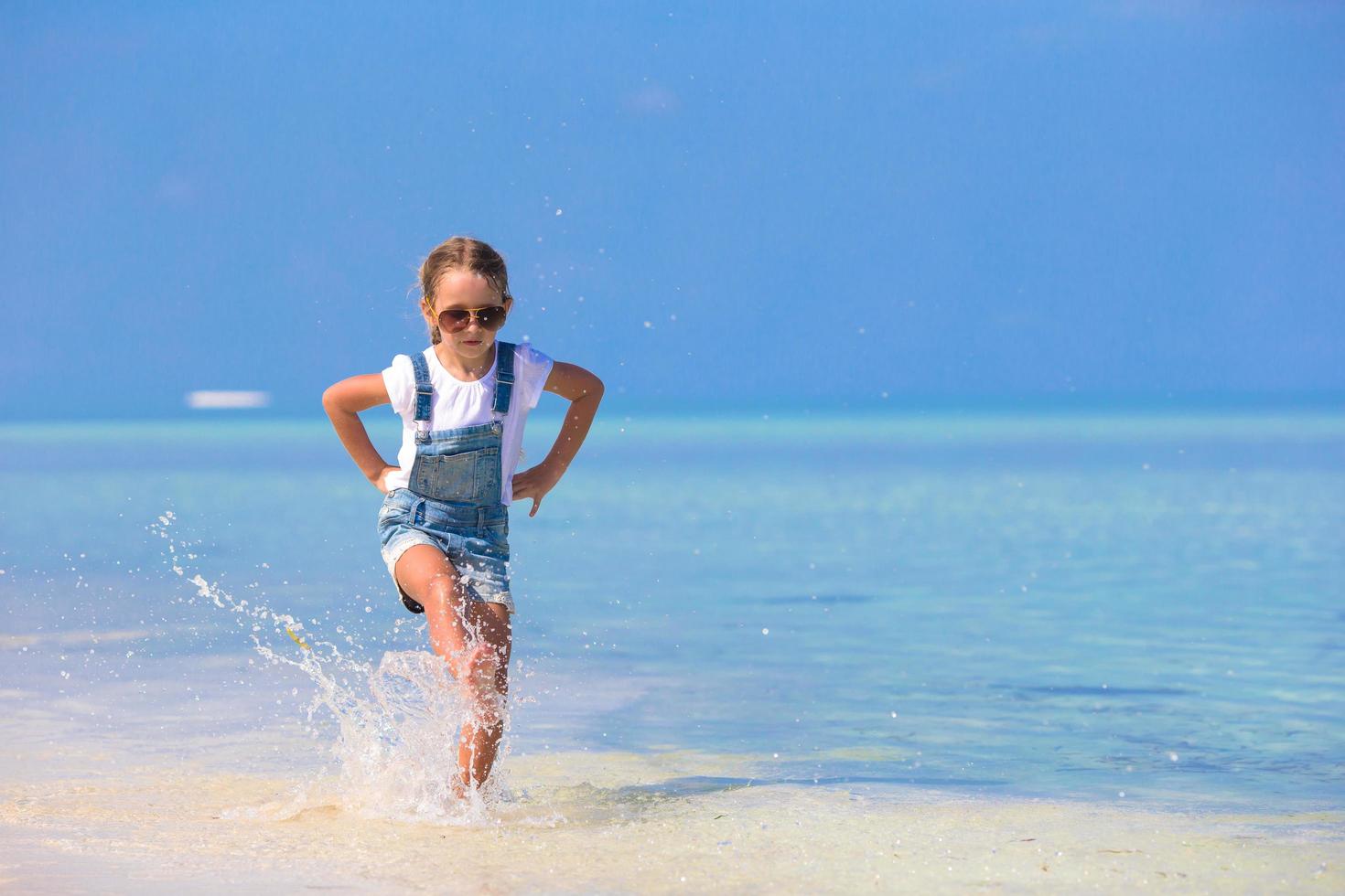 fille qui traverse l & # 39; eau à la plage photo