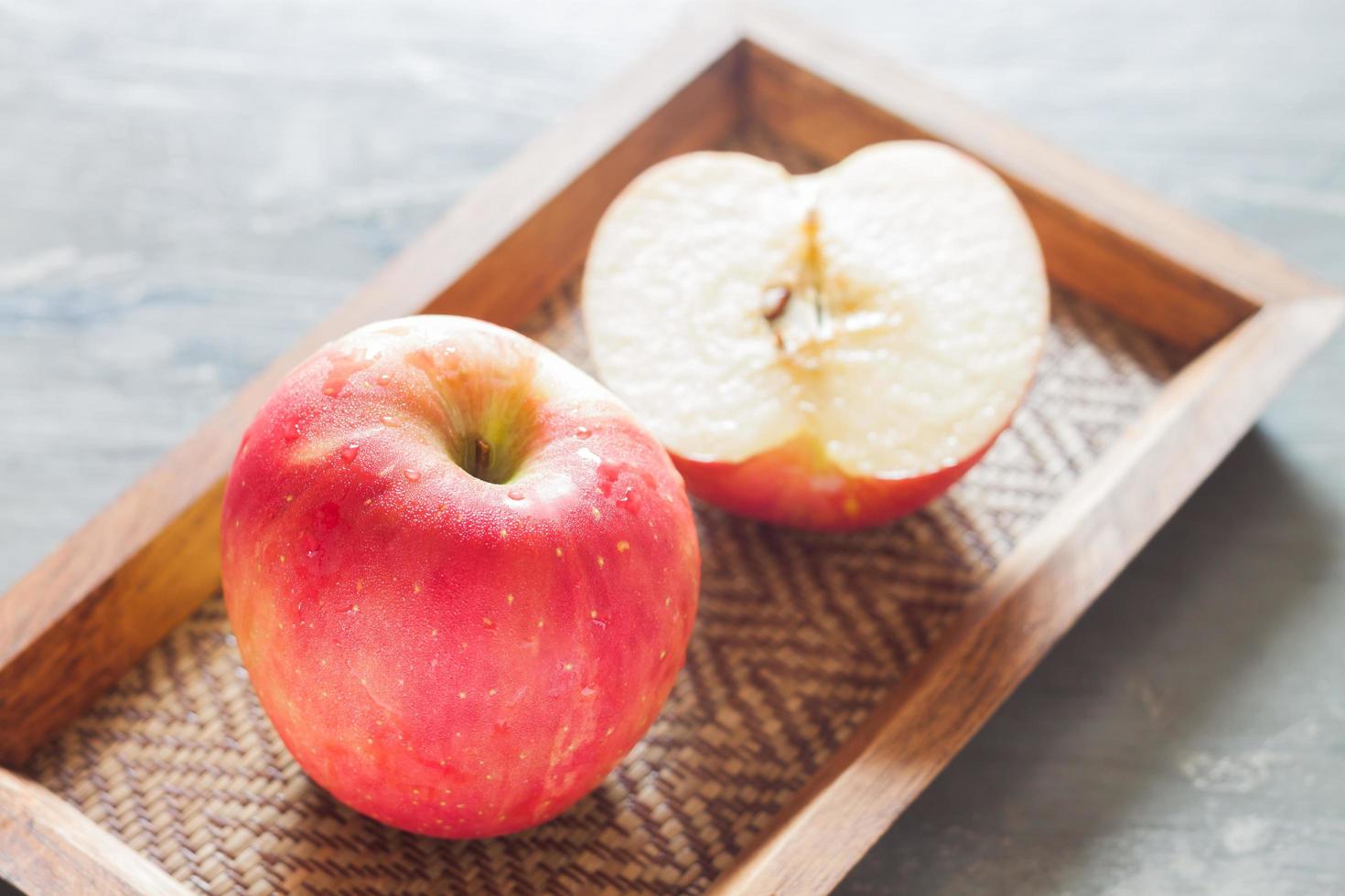 deux pommes rouges sur un plateau en bois photo