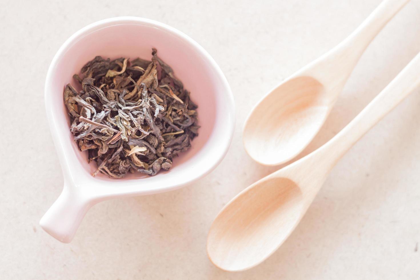 thé oolong dans une tasse en céramique et cuillères en bois vides photo