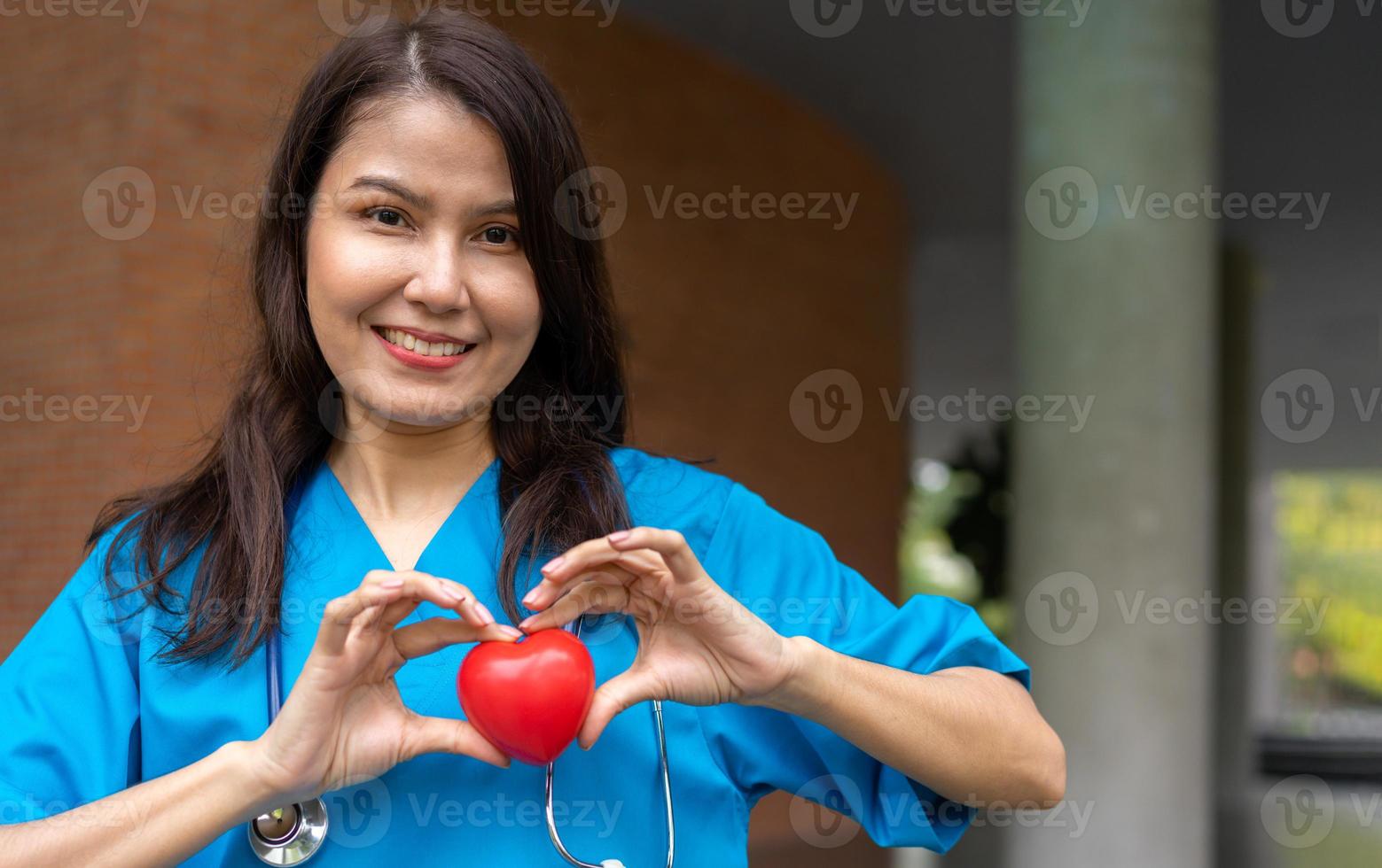 femme médecin de maladies cardiovasculaires ou cardiologue avec stéthoscope tenant coeur rouge, soins de santé médicaux et concept de service de personnel médical. photo