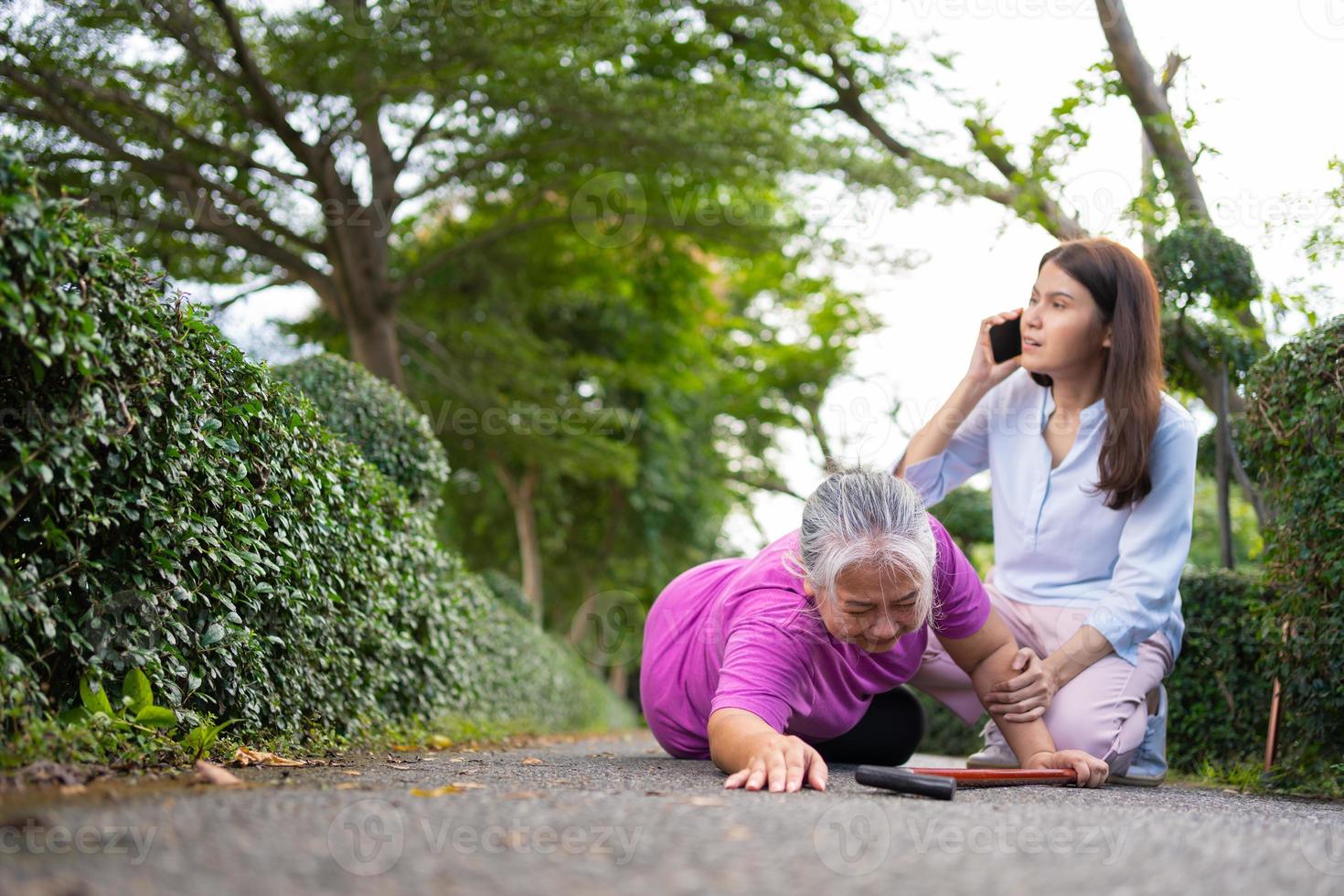 une femme âgée asiatique est tombée sur le sol couché parce que la faiblesse et la faiblesse des membres et la douleur d'un accident et la femme sont venues aider à soutenir et appeler l'urgence. concept d'assurance vieillesse et de soins de santé photo