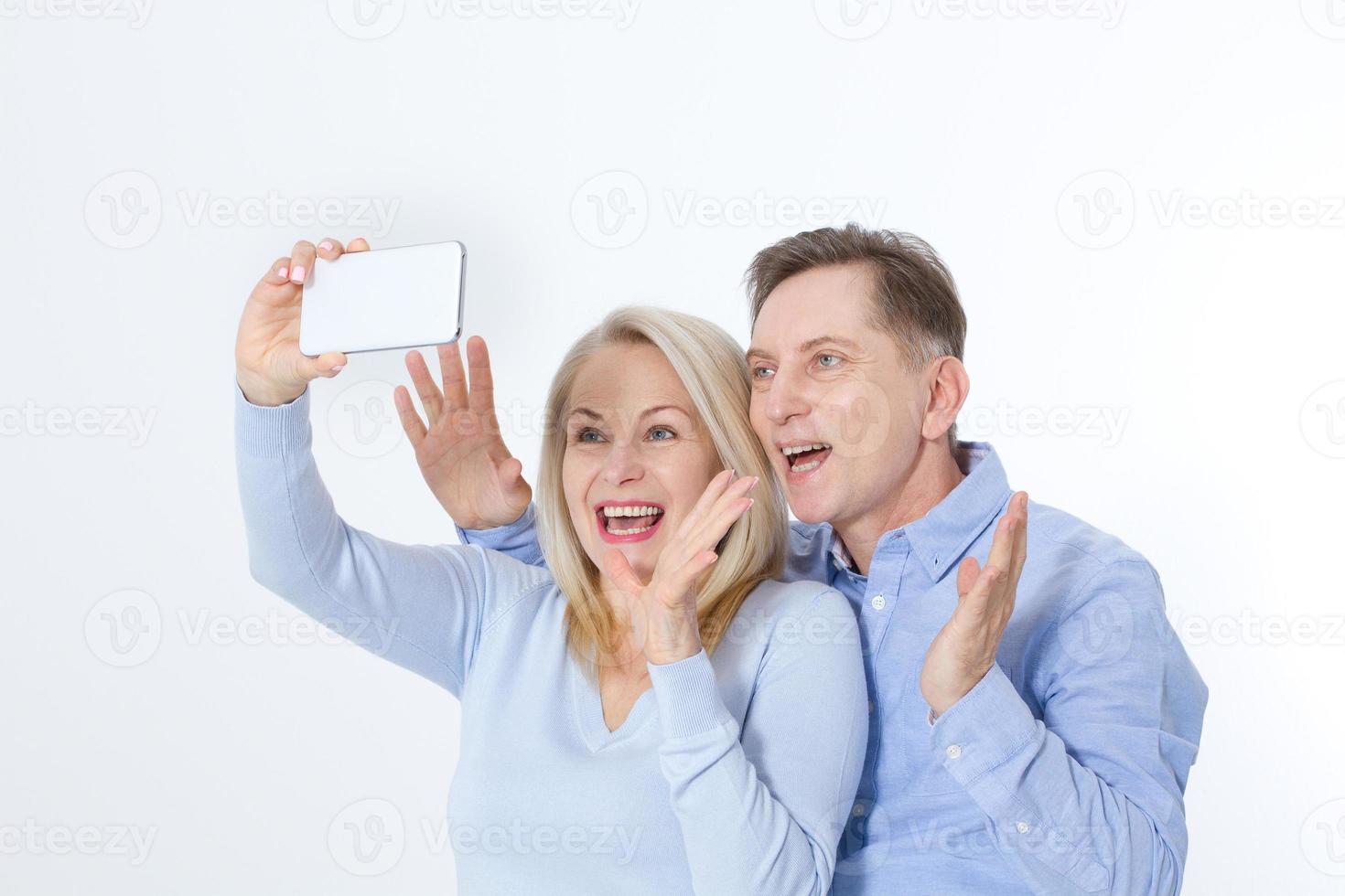 Heureux couple prenant selfie avec smartphone isolé sur blanc photo