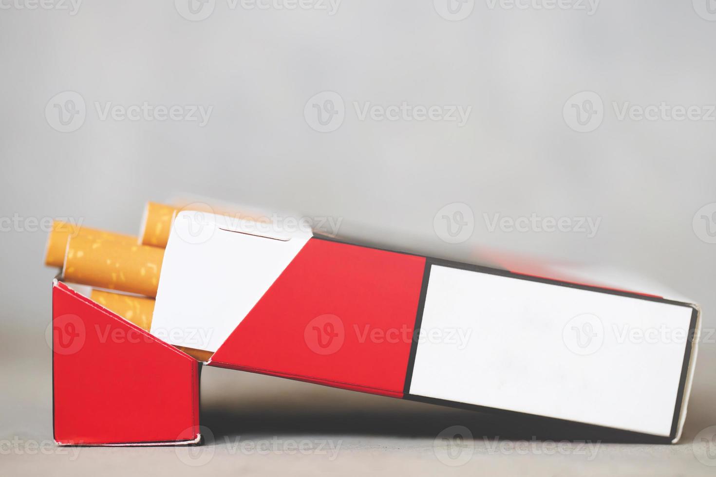 décollez-le du paquet de cigarettes préparez-le à fumer sur un fond en bois blanc. ligne d'emballage. la photo filtre la lumière naturelle.