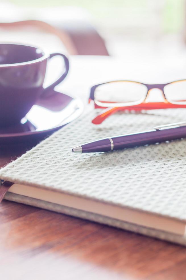 stylo et lunettes sur un cahier vert photo