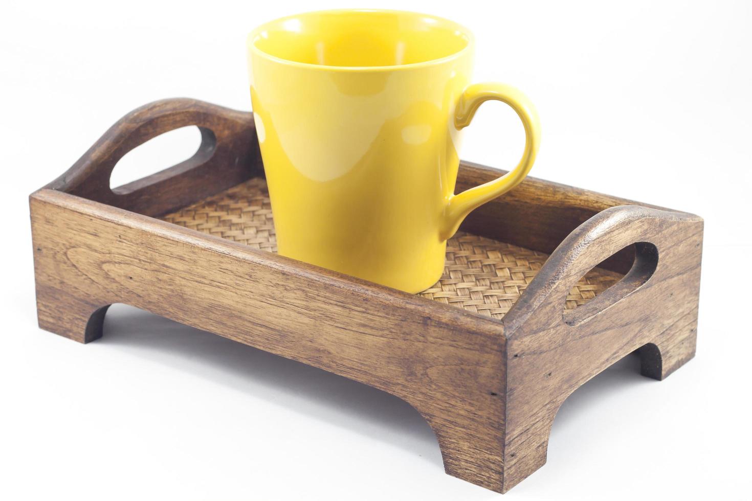 Mug jaune sur un plateau en bois photo