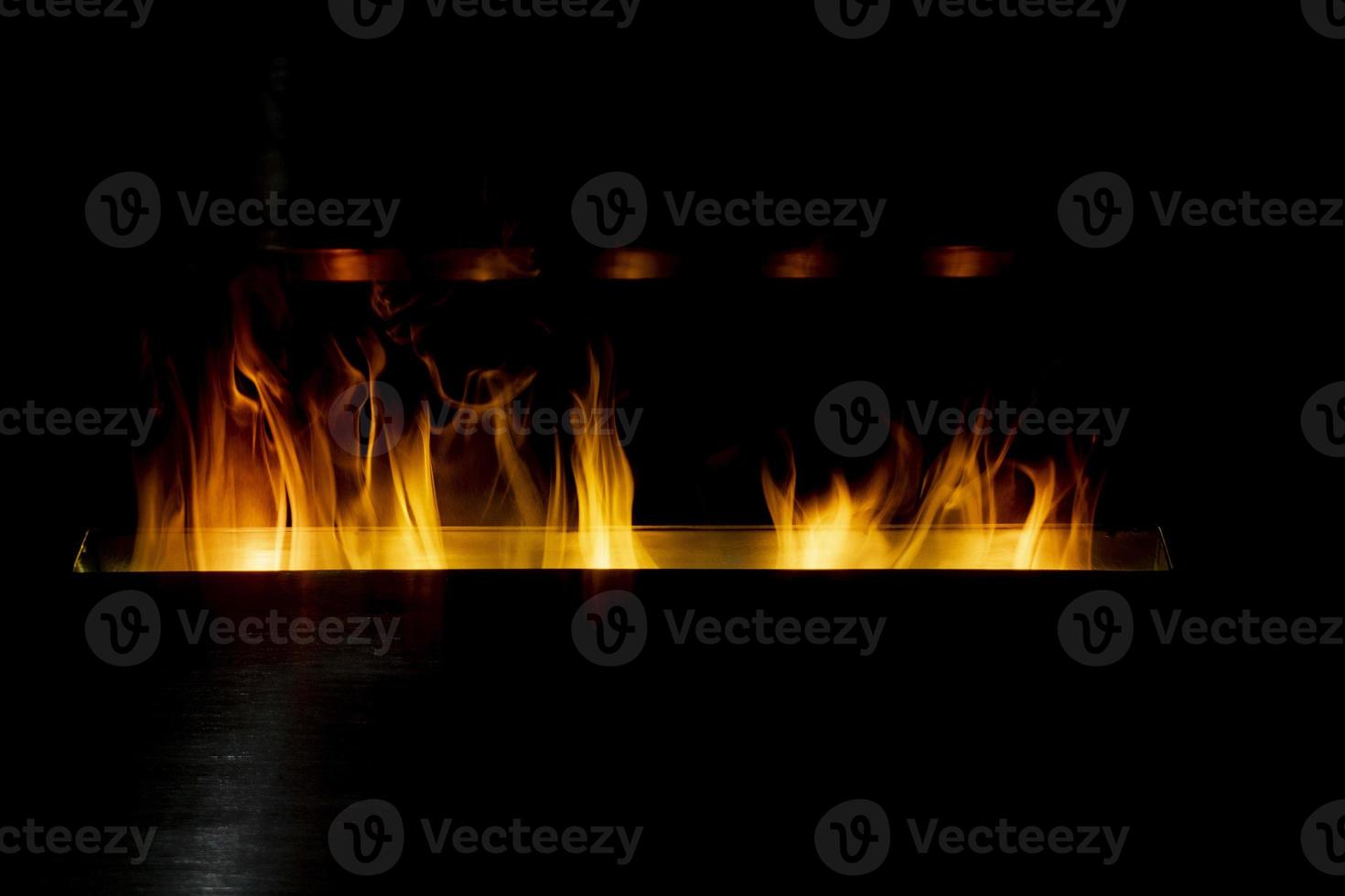 Cheminée au bioéthanol détail flammes sur fond noir photo