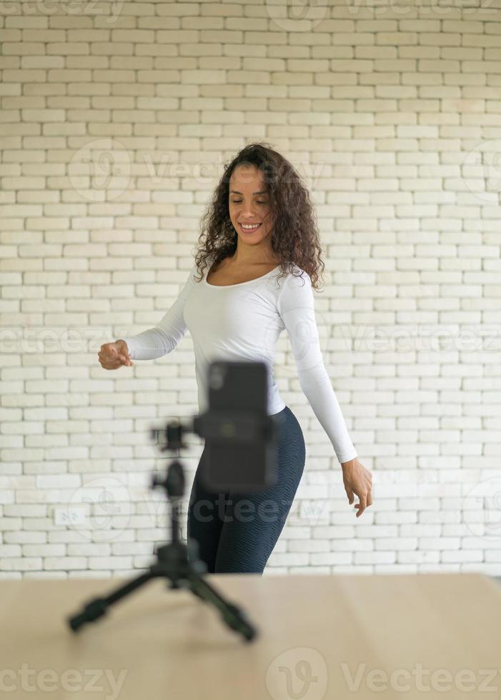 une femme latine a créé sa vidéo de danse avec l'appareil photo d'un smartphone. pour partager la vidéo à l'application de médias sociaux.