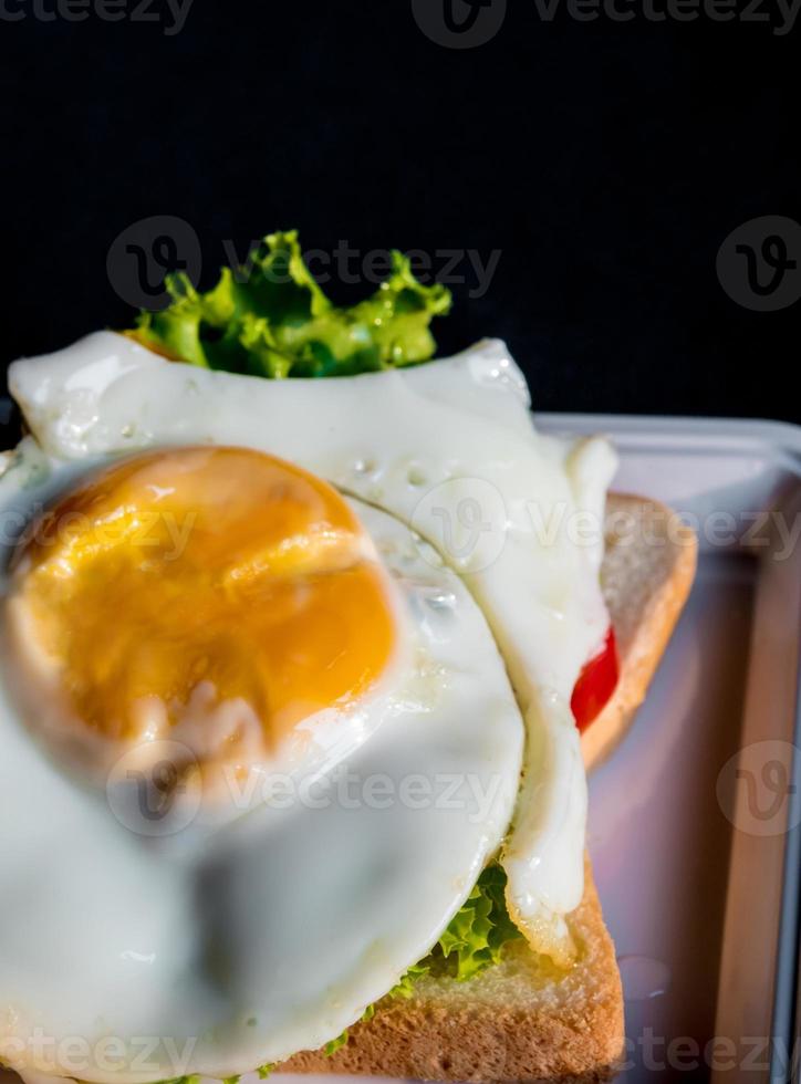 œuf au plat et légumes sur pain de mie photo