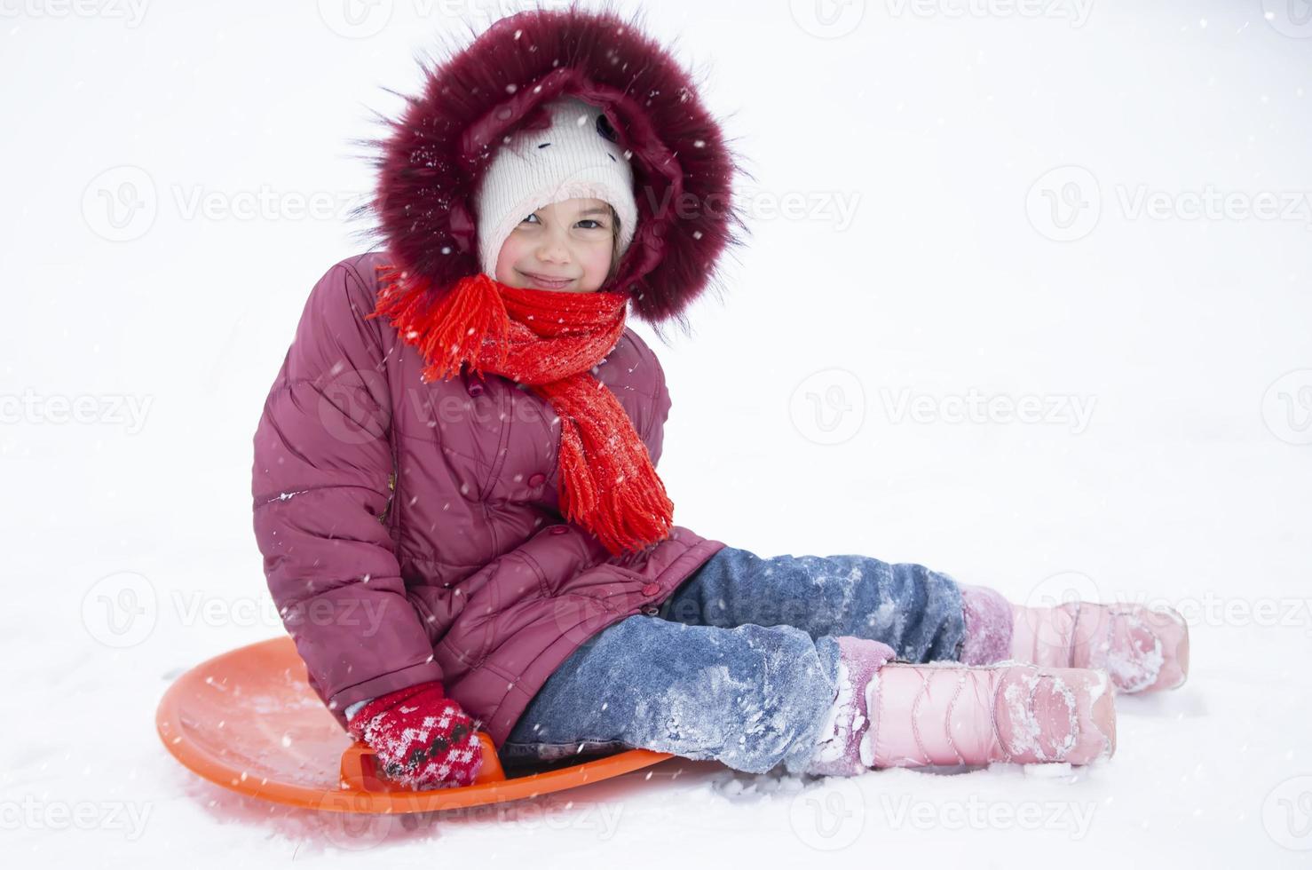 enfant en hiver. la fille fait de la luge. photo