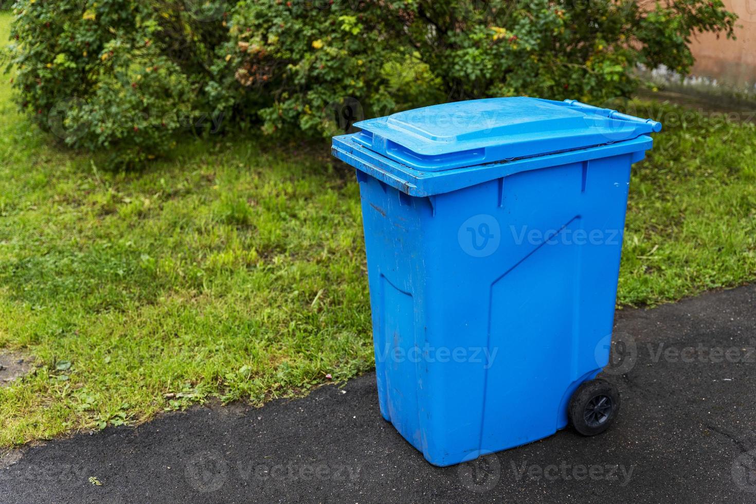 poubelle bleue en plastique dans la cour d'un immeuble résidentiel photo