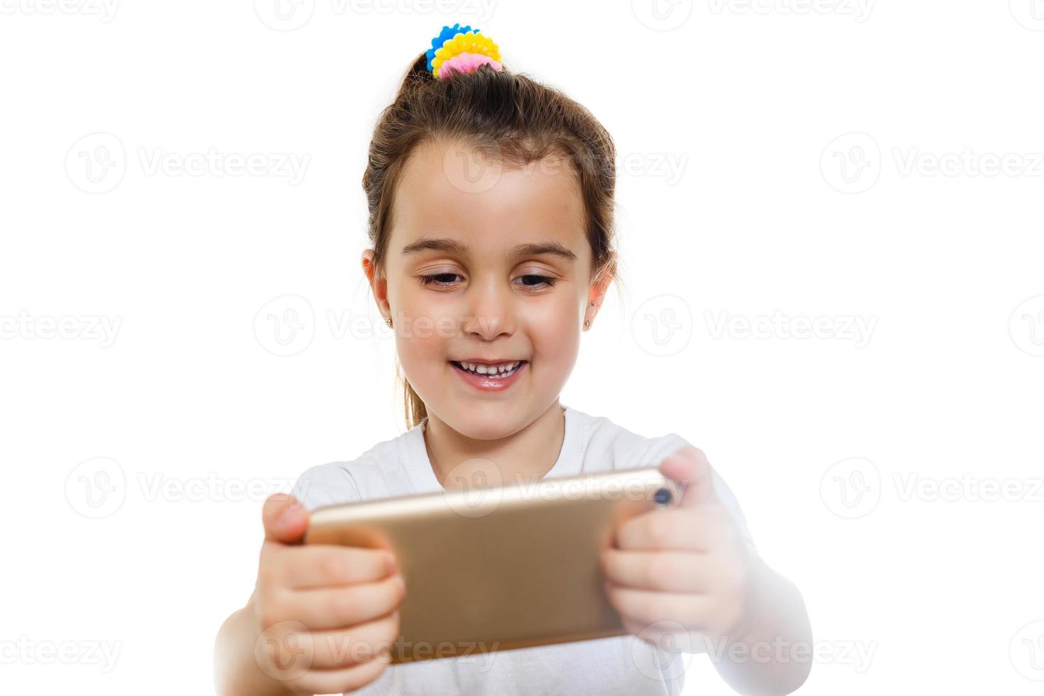 petite fille regarde le dessin animé sur le téléphone mobile dans le concept de fond de mur blanc photo