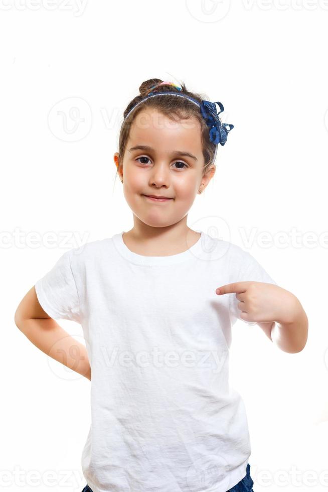 petite fille en t-shirt blanc décontracté indique un espace vide pour la création de logo photo
