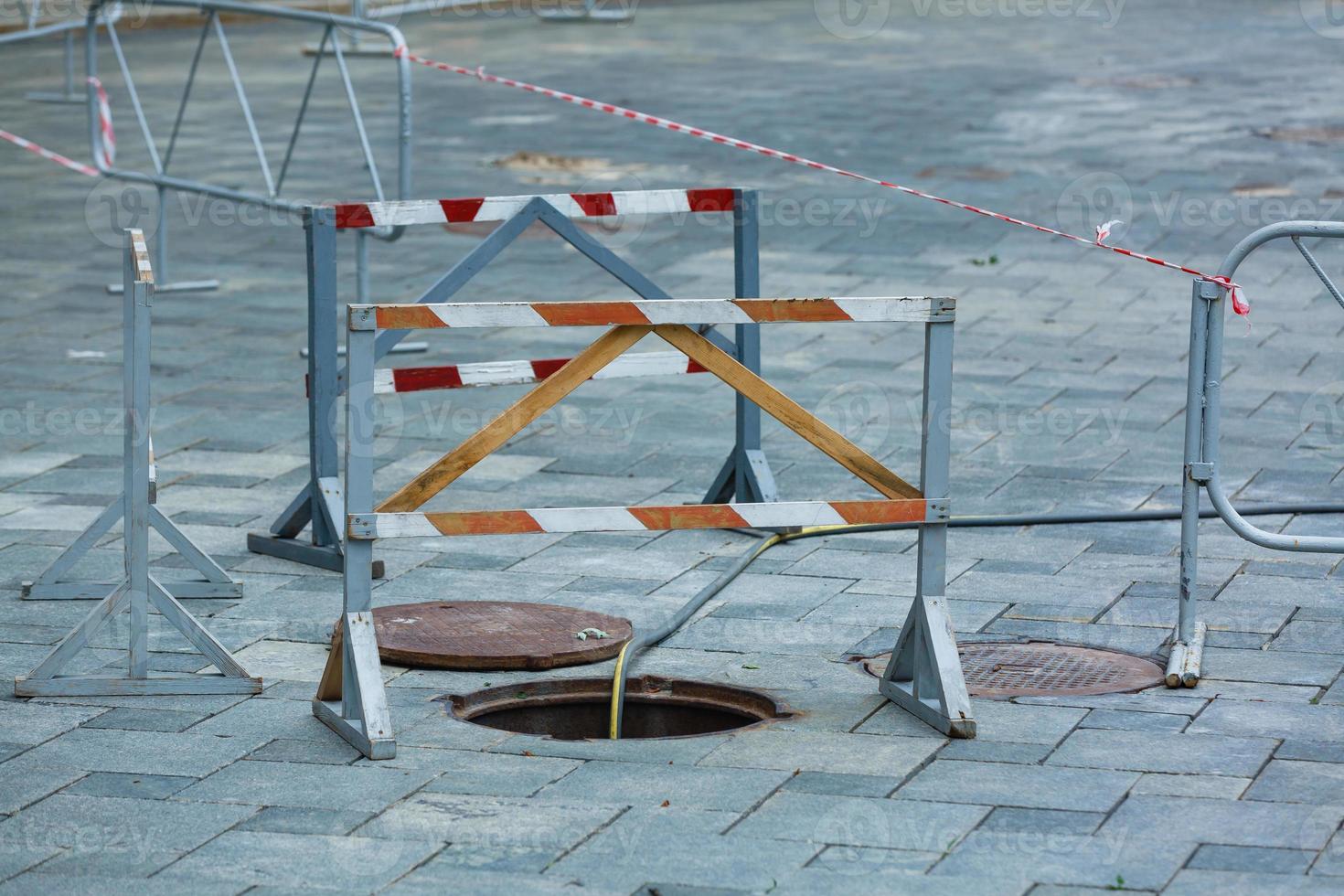 Trou d'homme d'égout ouvert non sécurisé dans la rue de la ville photo