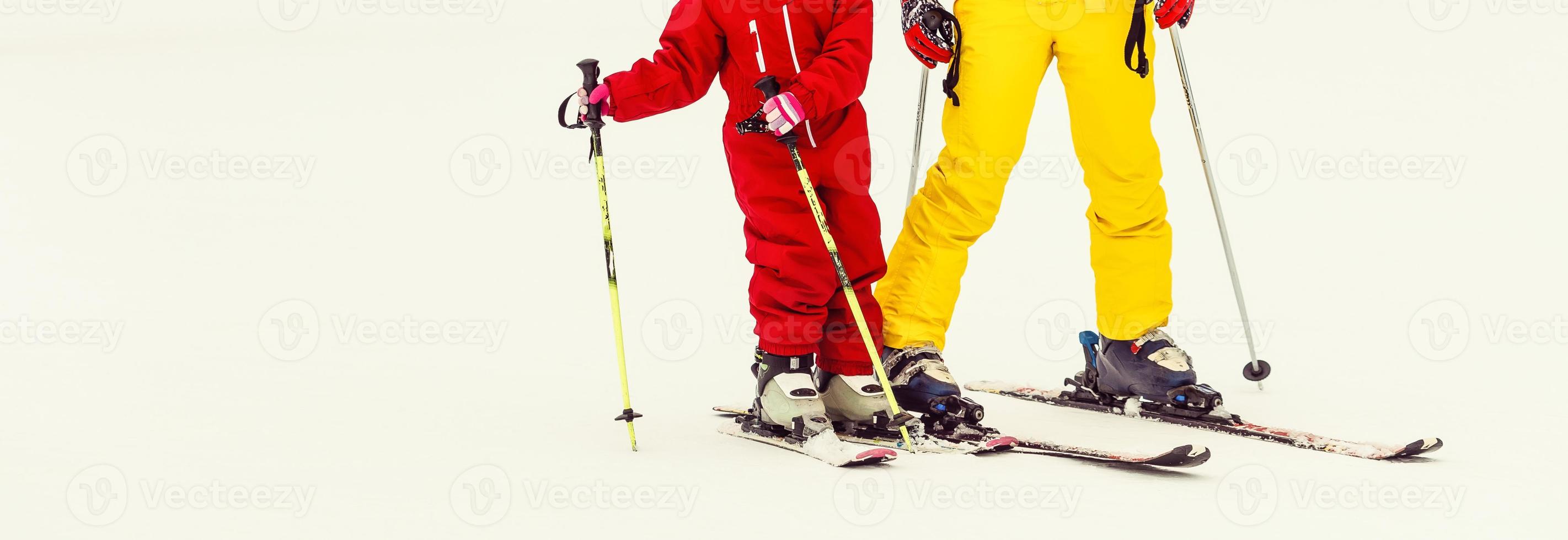 petite fille et une femme skieurs au sommet d'une pente de montagne enneigée allant skier photo