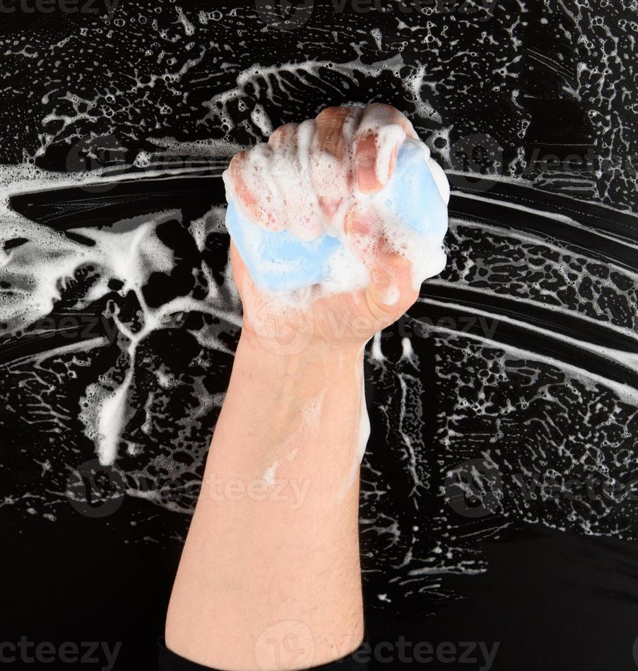 processus de lavage des mains avec du savon bleu, parties du corps en mousse blanche photo