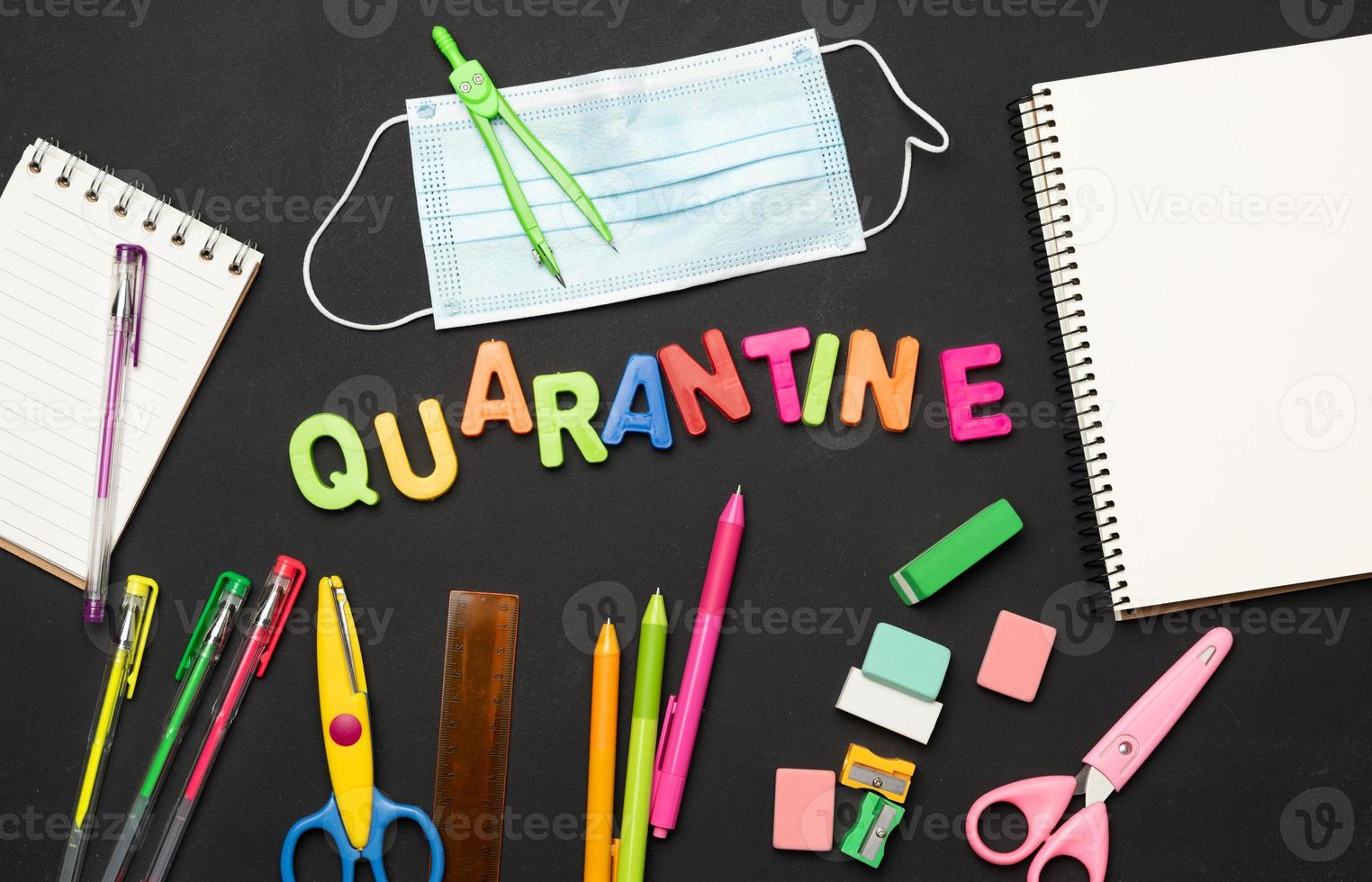 inscription en quarantaine à partir de lettres en plastique multicolores et de fournitures scolaires sur tableau noir photo