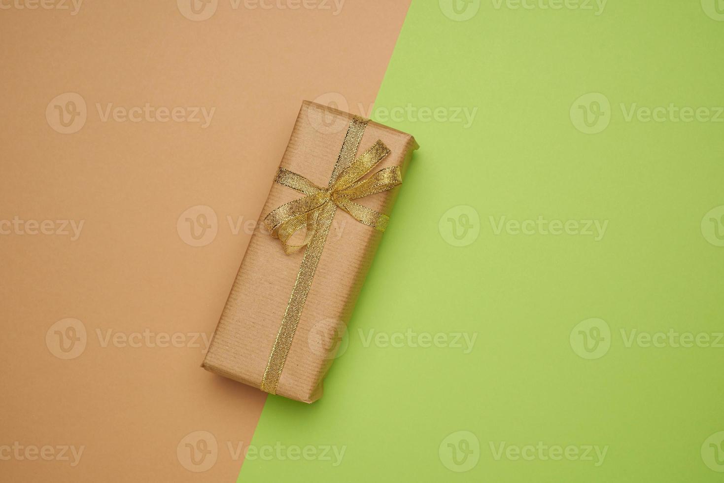 boîte rectangulaire enveloppée de papier brun et attachée avec un ruban de soie avec un arc photo