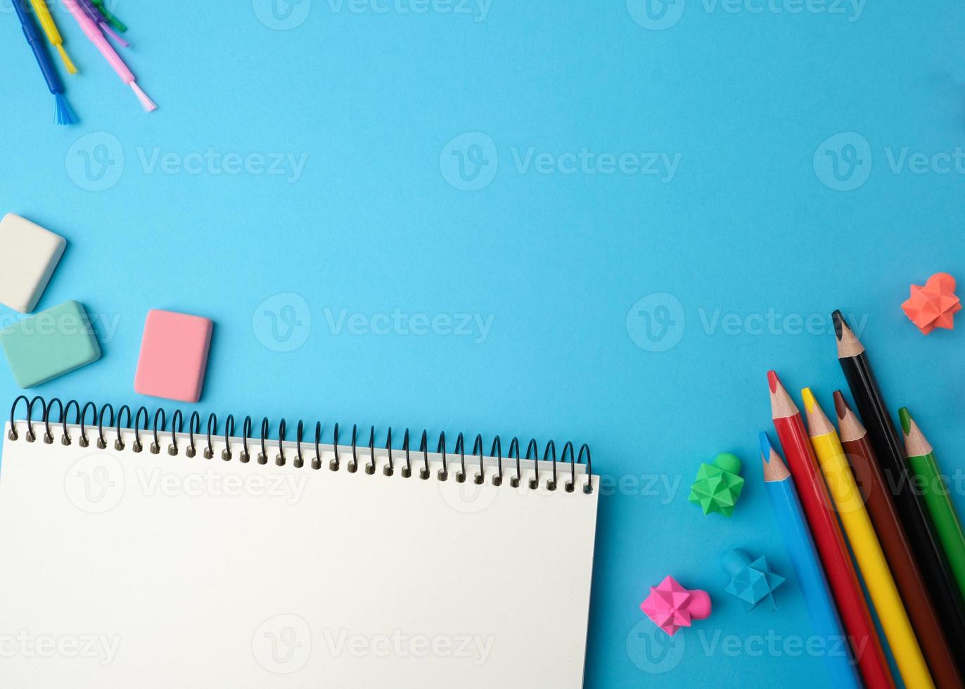 cahier avec des feuilles blanches vierges, des crayons en bois multicolores photo