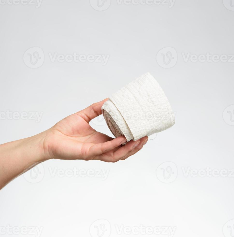 femme tient en main un bandage élastique blanc pour le corps photo