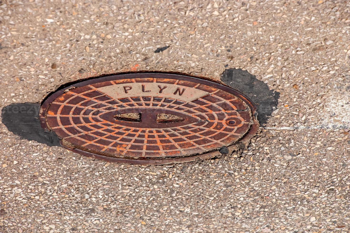 couvercle de trou d'homme du système de gazoduc. une trappe métallique massive pour l'accès aux communications de la ville dans le trottoir. photo