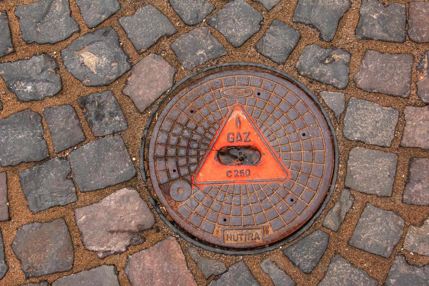 couvercle de trou d'homme du système de gazoduc. une trappe métallique massive pour l'accès aux communications de la ville dans le trottoir. photo