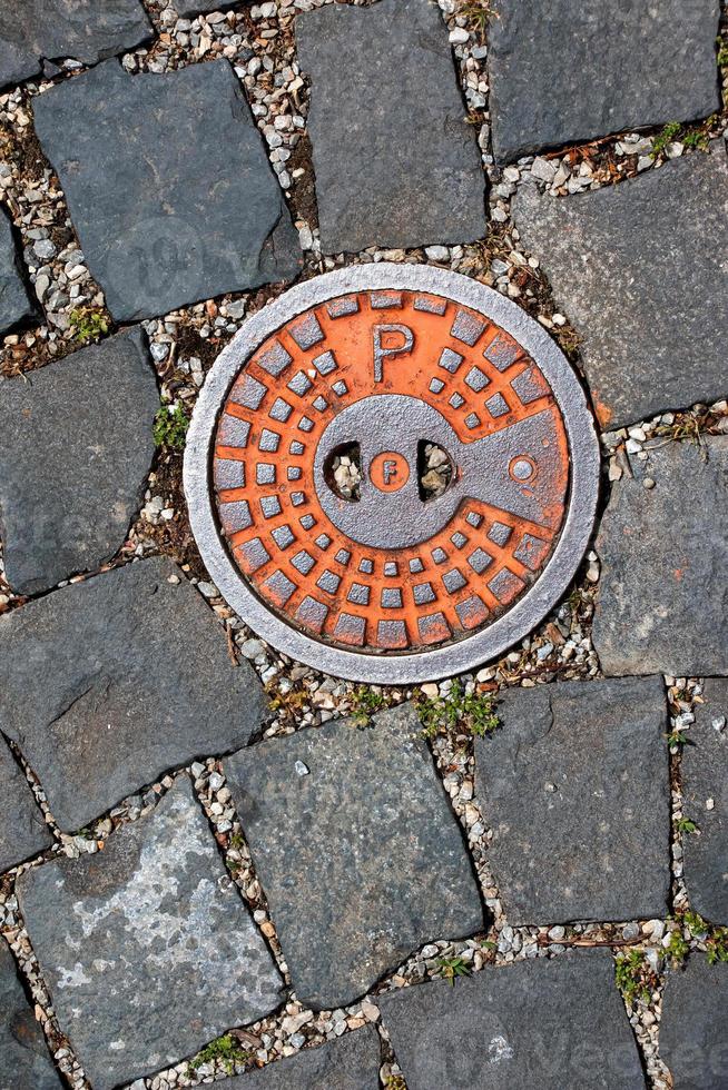 couvercle de trou d'homme du système de gazoduc. une trappe métallique massive pour l'accès aux communications de la ville dans le trottoir. photo