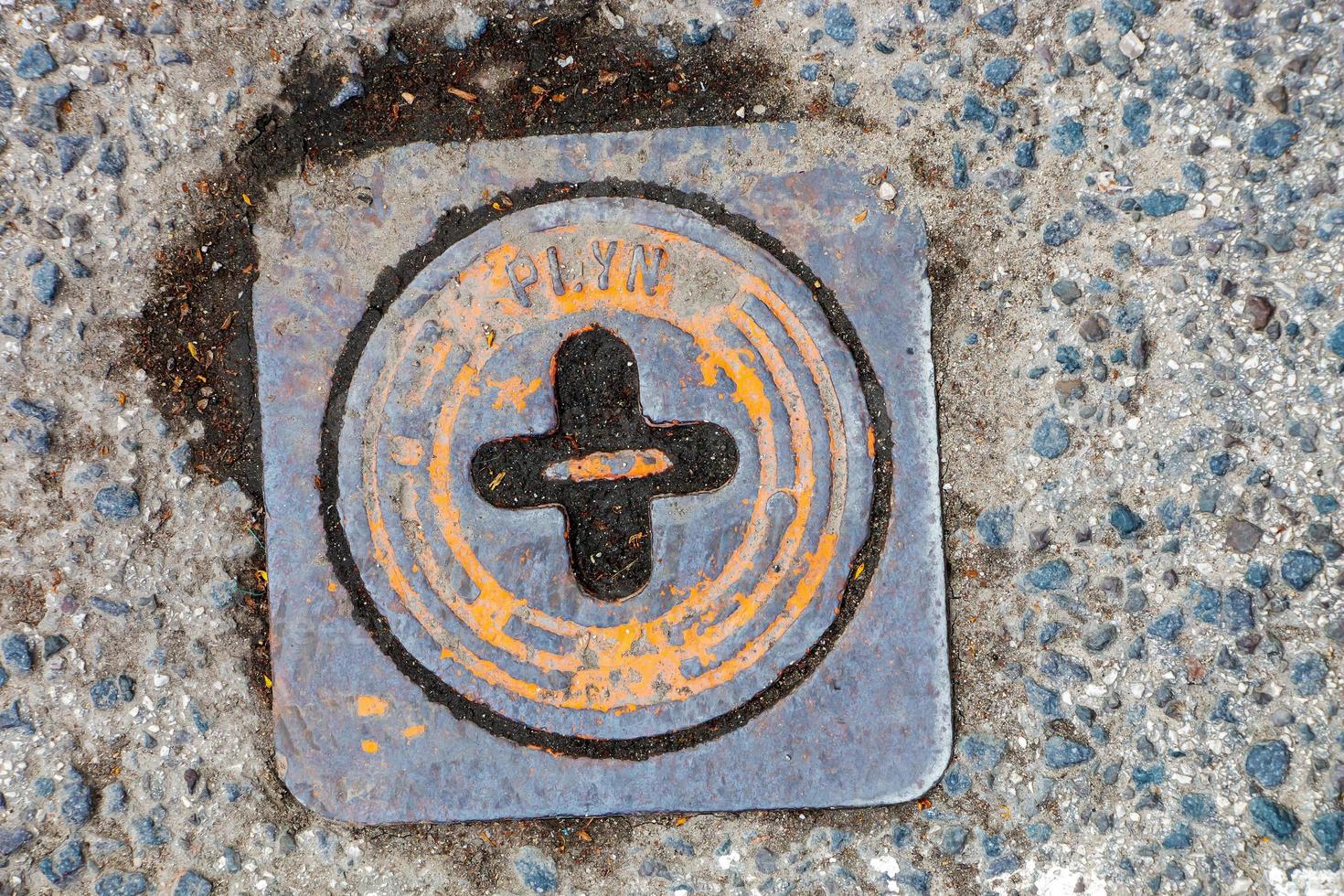 couvercle de trou d'homme du système de gazoduc. une trappe métallique massive pour l'accès aux communications de la ville dans le trottoir. photo