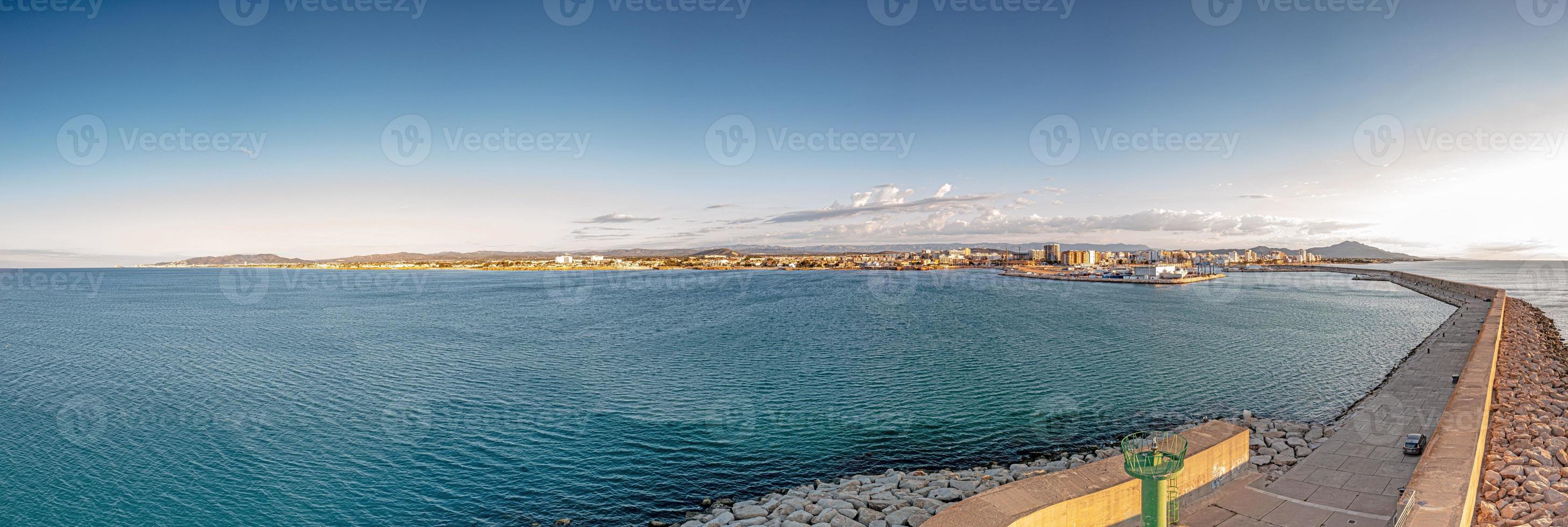 panorama de drone de la ville espagnole de vinaros avec le grand brise-lames à l'entrée du port pendant le lever du soleil photo