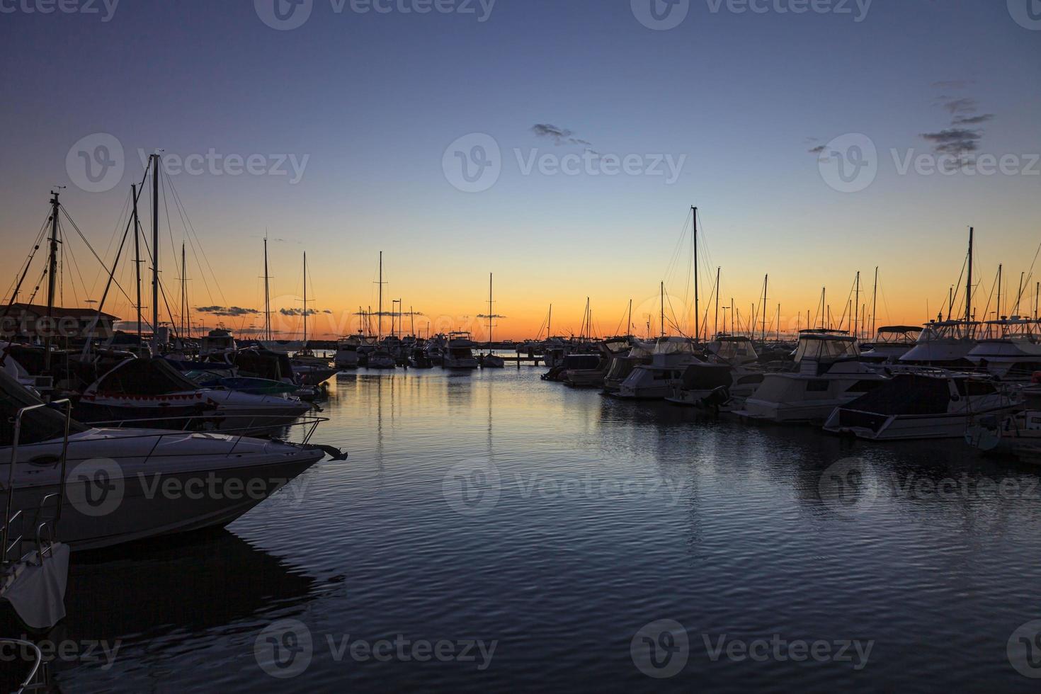 image de yachts dans la marina après le coucher du soleil avec des reflets d'eau photo