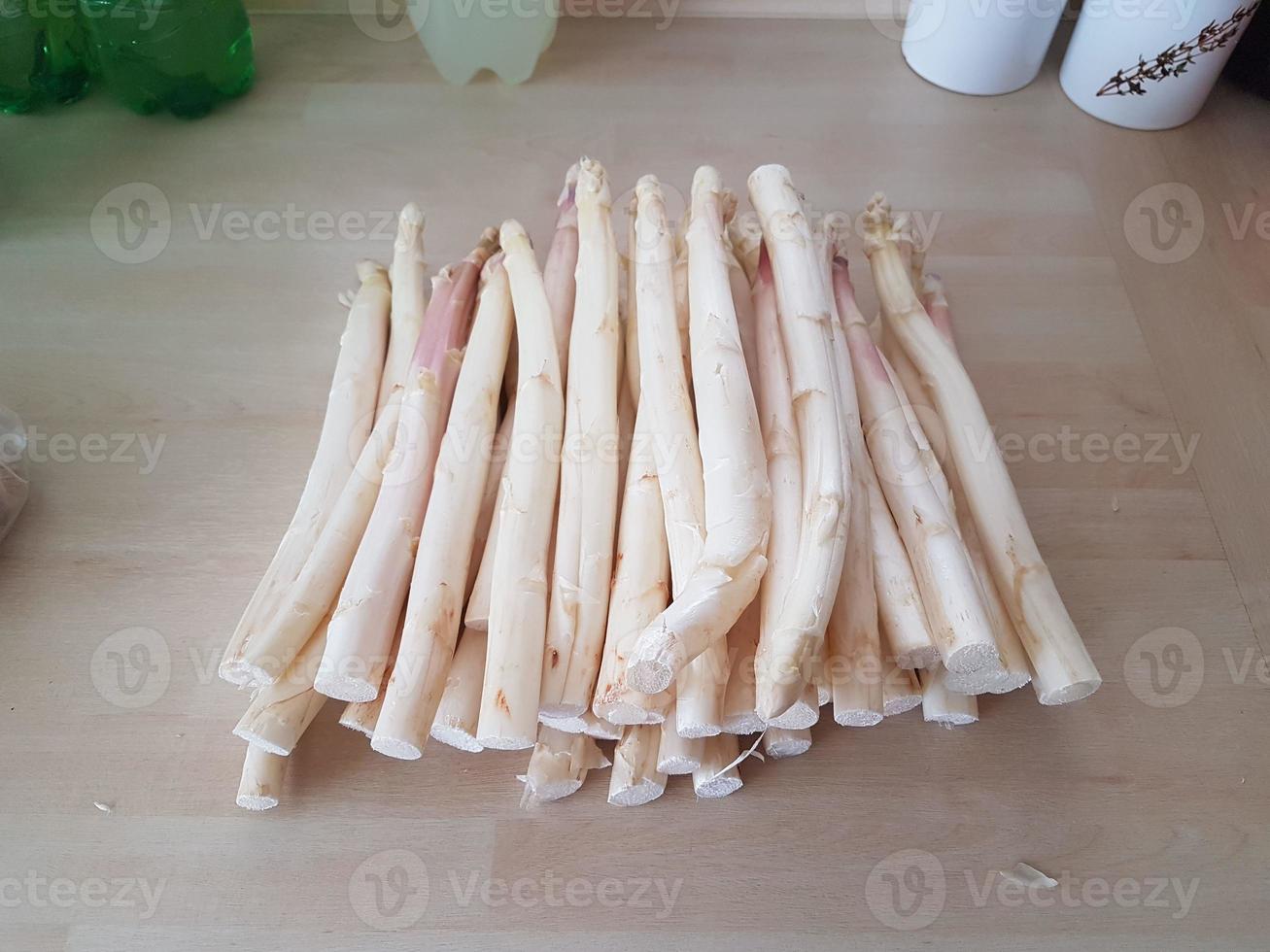 les asperges fraîchement percées se trouvent sur le plan de travail de la cuisine pour être traitées photo