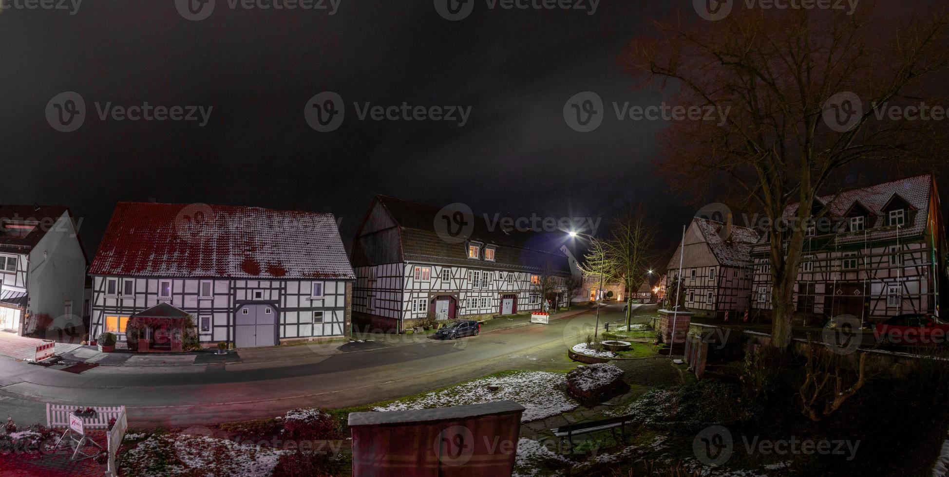 scène nocturne d'une vieille ville allemande avec des maisons à colombages et une rue pavée par temps humide photo