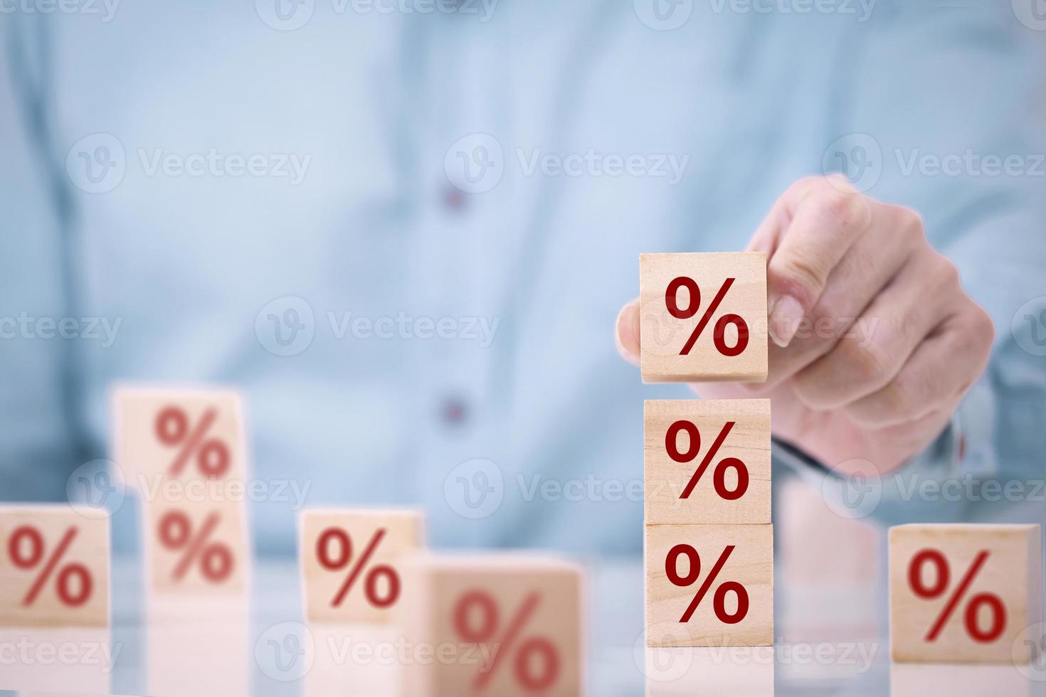 l'homme d'affaires choisit un bloc de cube en bois sur le dessus avec l'icône de symbole de pourcentage , le concept de taux financiers , de taux d'intérêt et de taux hypothécaires photo