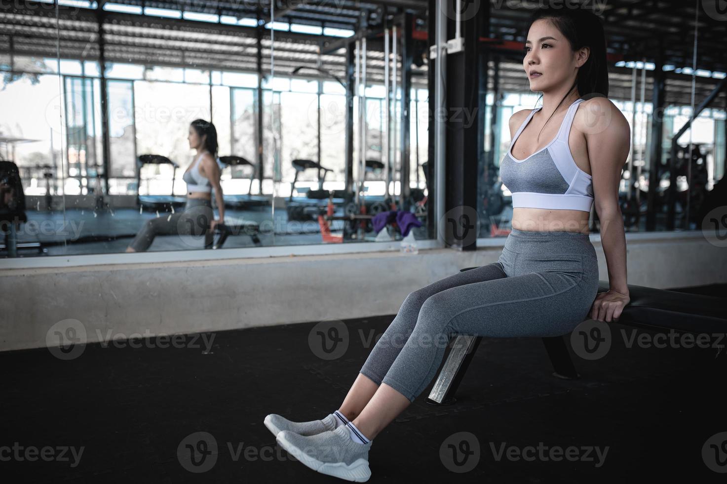 gros plan belle sportive asiatique porter un soutien-gorge de sport sur le mur de la salle de gym, la thaïlande aime la santé, le concept d'entraînement de femme mince photo