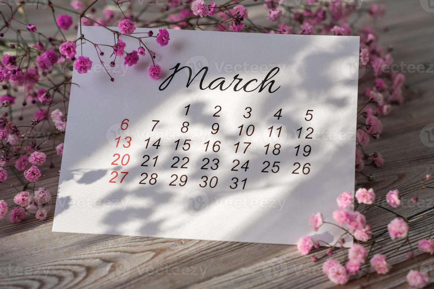 calendrier de mars 2022 et fleurs roses au soleil printanier photo