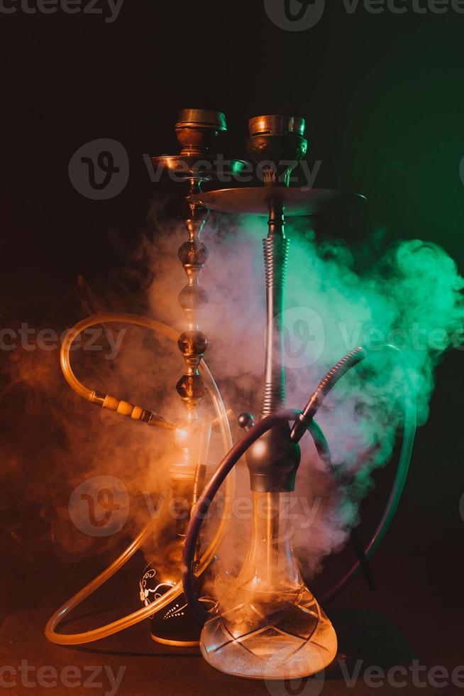 narguilé moderne, chicha sur fond noir fumé avec éclairage coloré et fumée photo