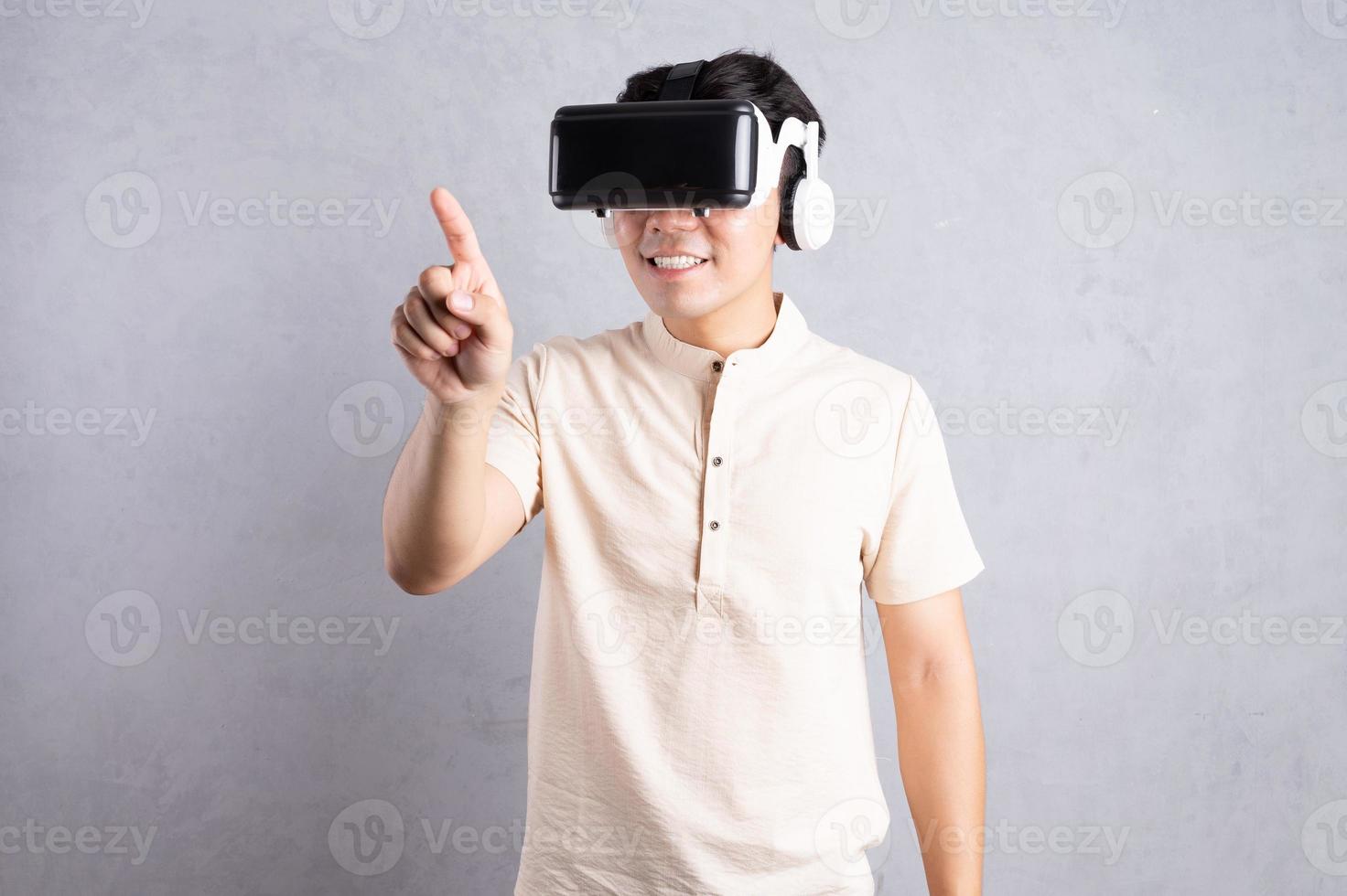 jeune homme asiatique à l'aide de lunettes vr sur fond photo