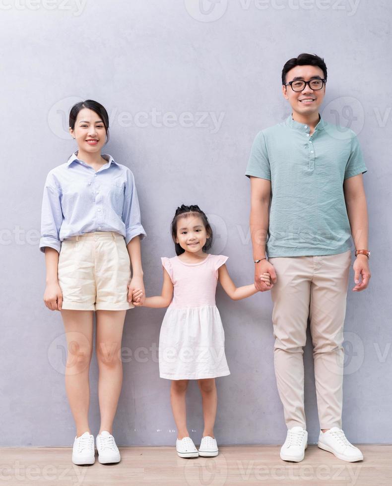 jeune famille asiatique debout sur fond photo