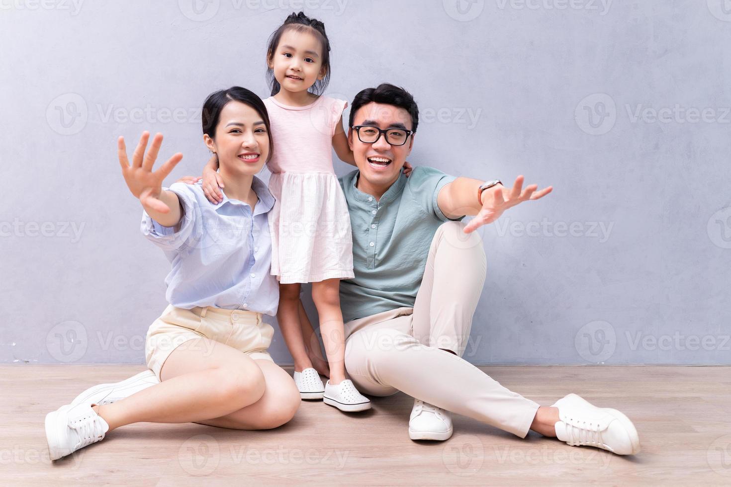 jeune famille asiatique assise sur le sol photo