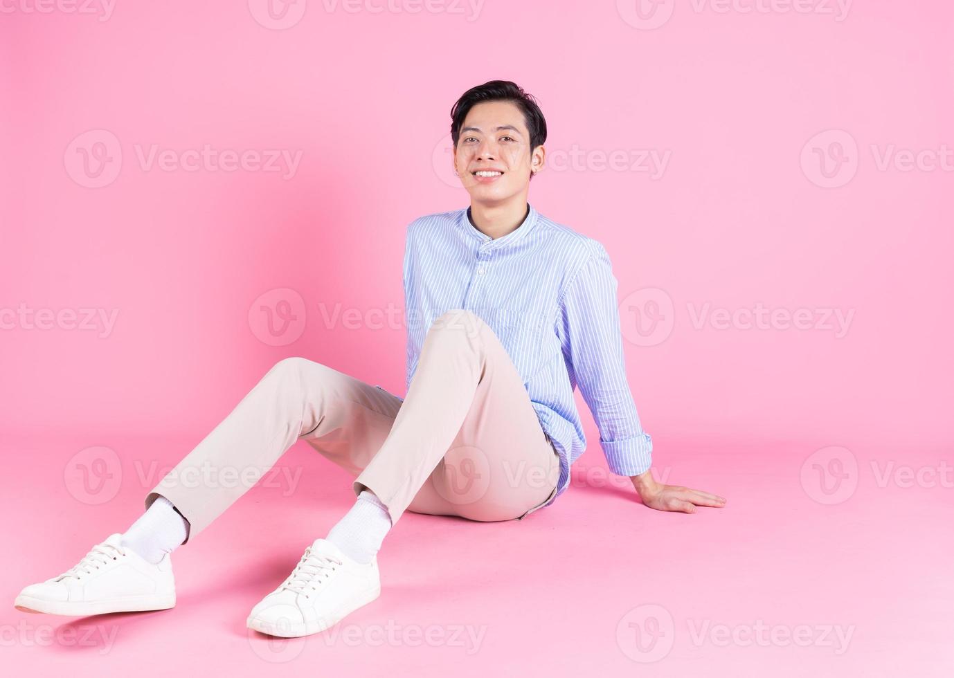 jeune homme asiatique assis sur fond photo
