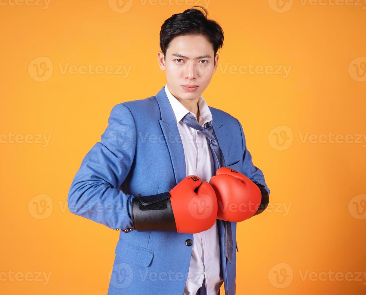 image d'un jeune homme d'affaires asiatique en colère avec un gant de boxe photo