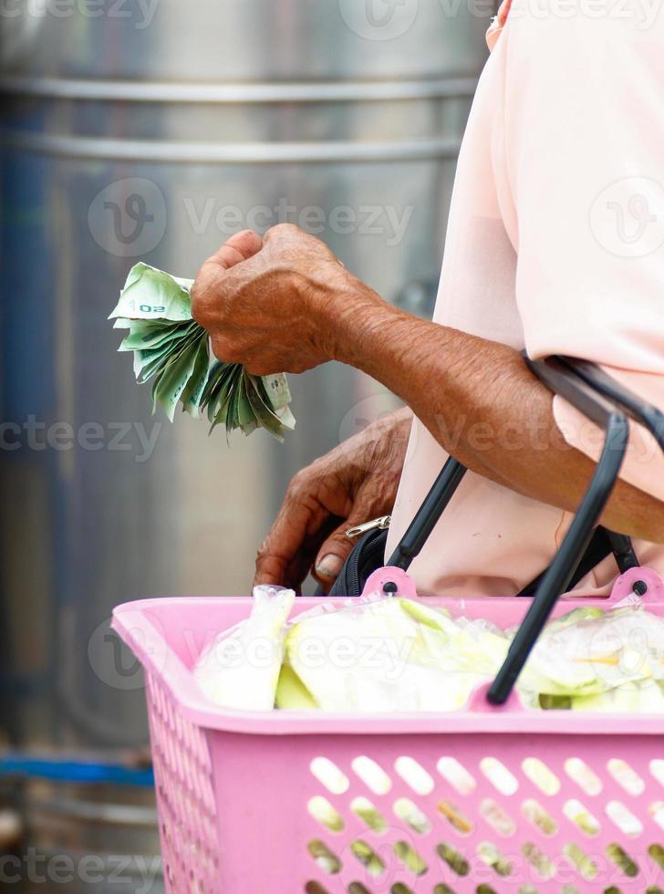 les mains d'une femme âgée tenant de l'argent photo