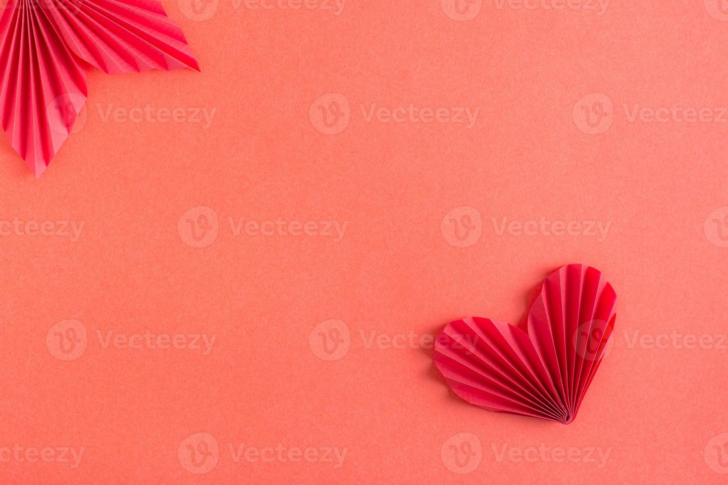 modèle avec coeur origami et feuille. fond monochrome rouge. copie espace photo