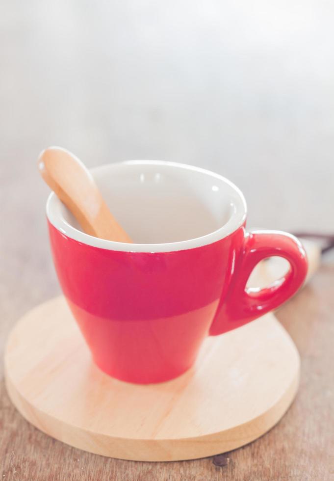 tasse rouge sur une assiette en bois photo