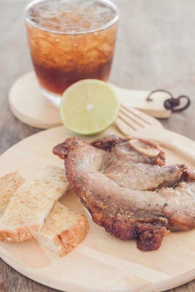 Steak de porc sur une assiette en bois photo