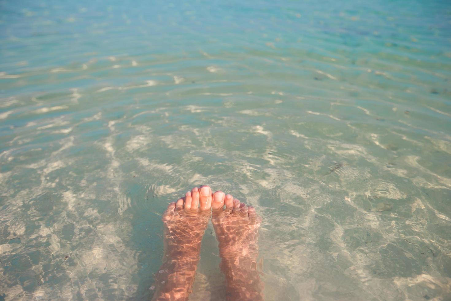 pieds dans l'eau claire de l'océan photo