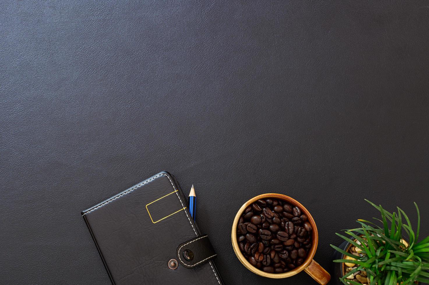 bureau noir avec grains de café et cahier photo