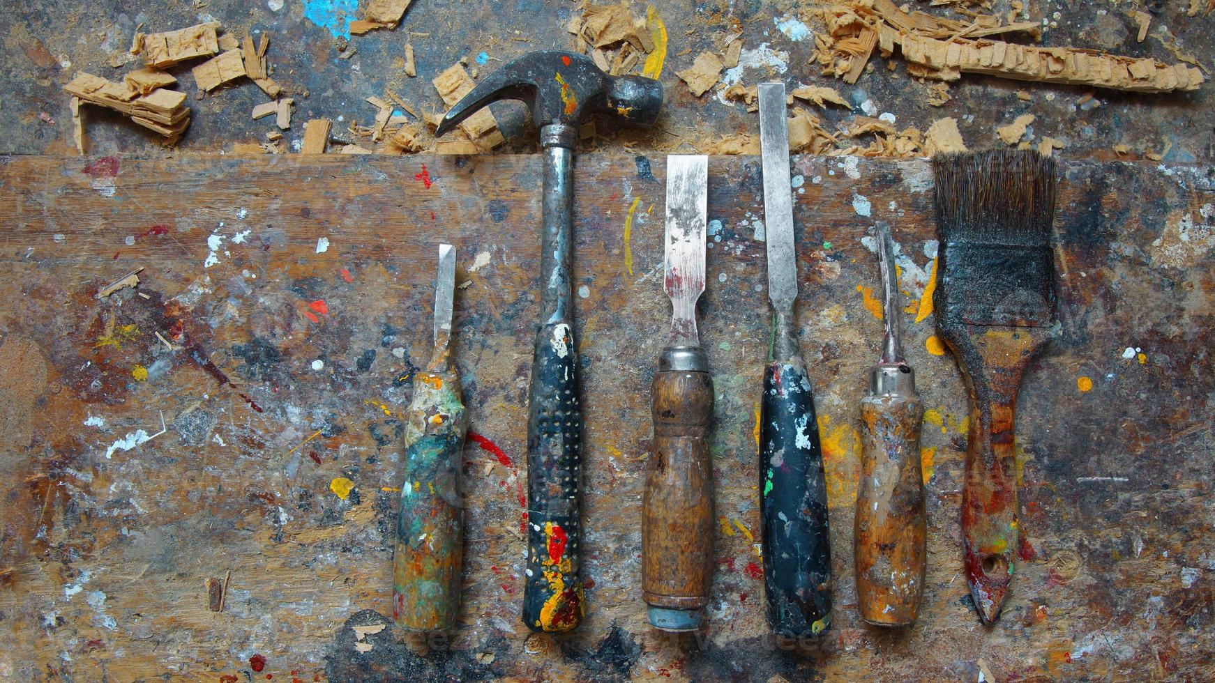 Vieux outils de menuiserie tachés de peinture sur table de travail éclaboussé de peinture photo