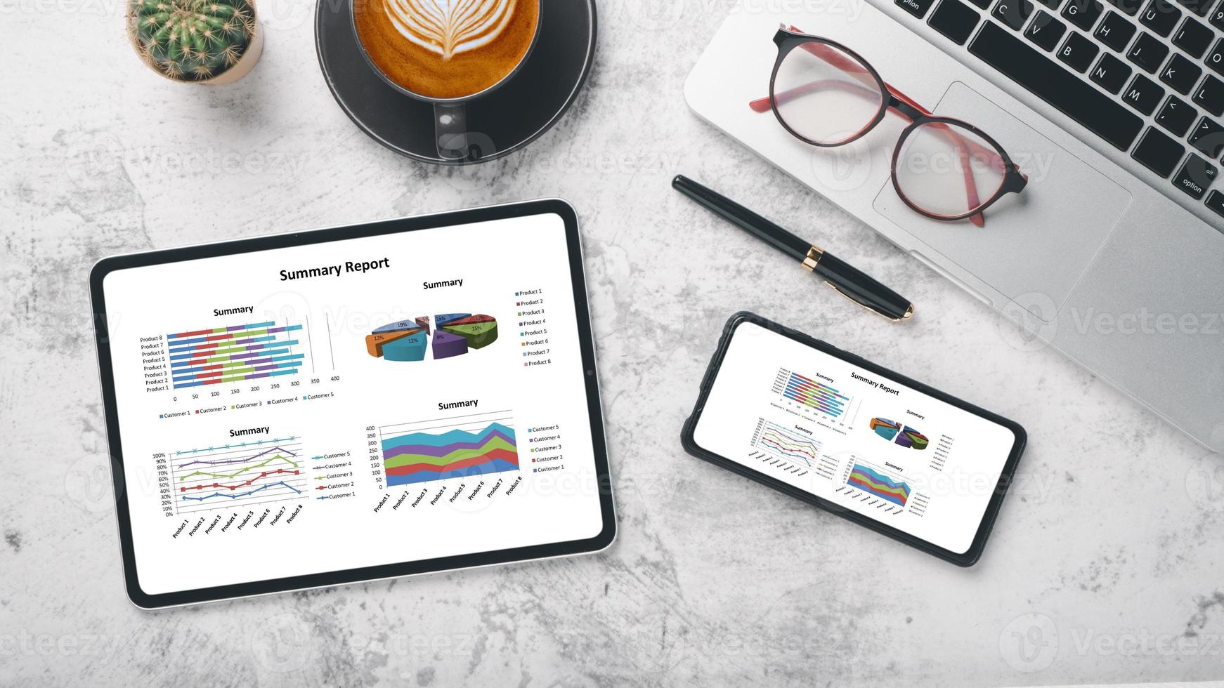 tablette et smartphone avec graphiques et rapports sur le lieu de travail de bureau. vue de dessus mise à plat photo